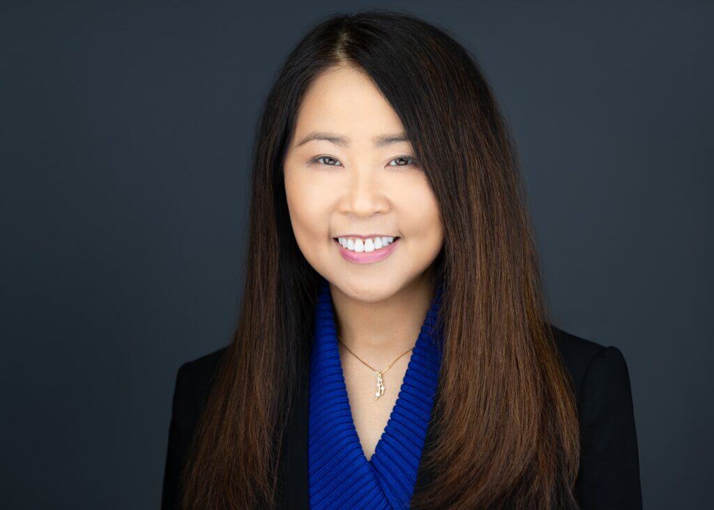 High-quality portrait of a professional Asian woman with long dark hair, smiling, representing smart health decisions.