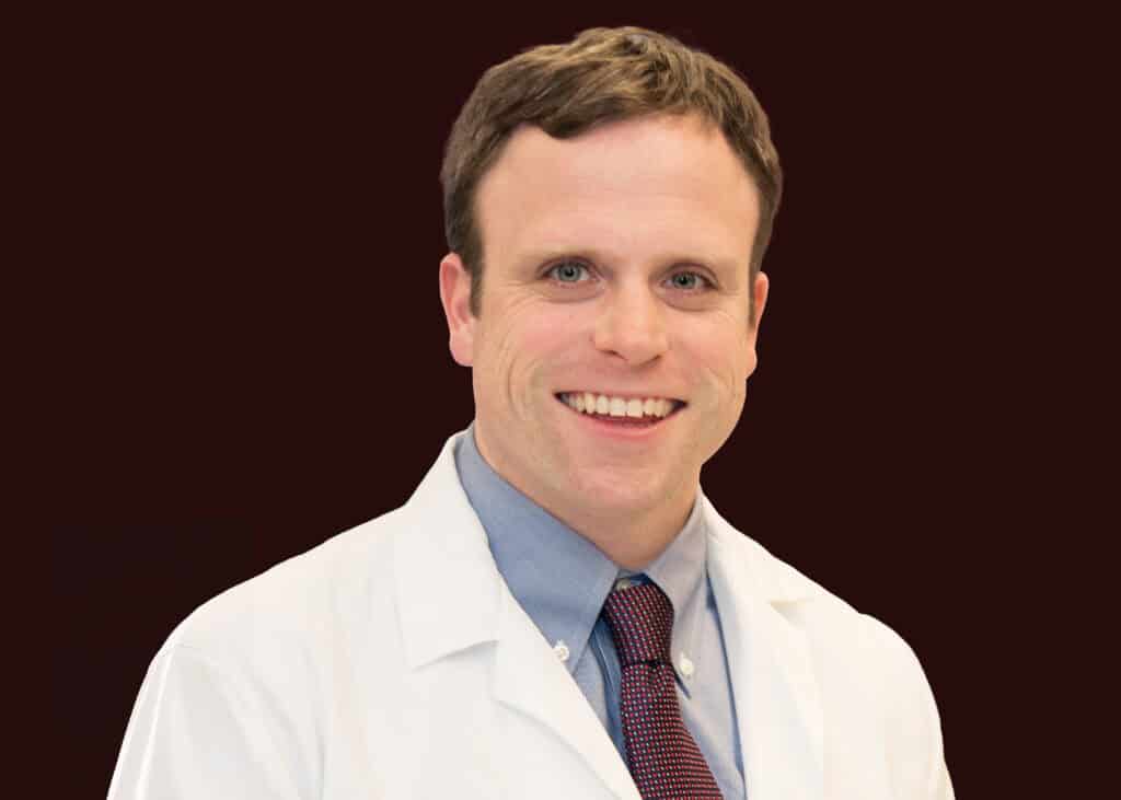 Friendly male doctor smiling, healthcare professional in white coat for smart health decisions.
