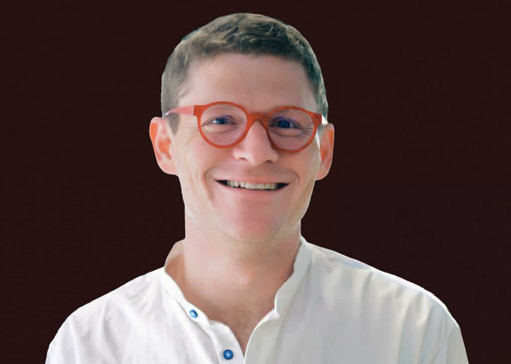 Stylish man wearing red glasses, smiling confidently, representing smart health decisions and digital health solutions.